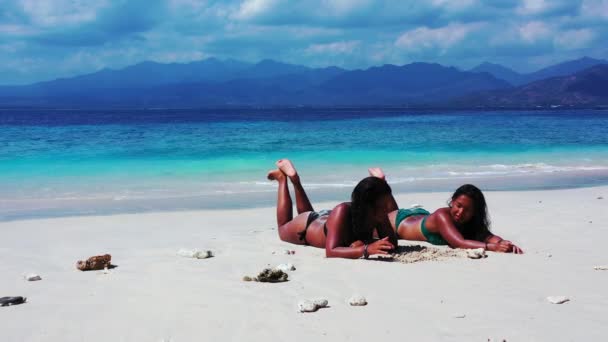 砂のビーチで日光浴をする2人の女の子 — ストック動画