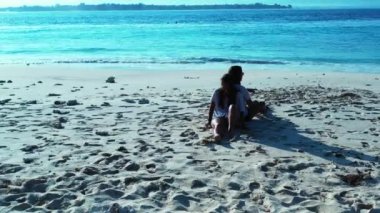 Güzel iki kız kumsalda oturuyor