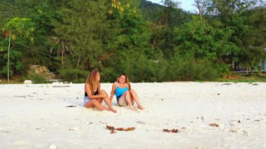 Tropik adanın kumlu sahillerinde dinlenen kızlar, yaz tatili konsept görüntüleri 