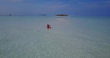 Genç bir adam ve kadın deniz kıyısında güneşleniyorlardı. Tropik bir tatil köyünde dinlenen güzel bir çift.   