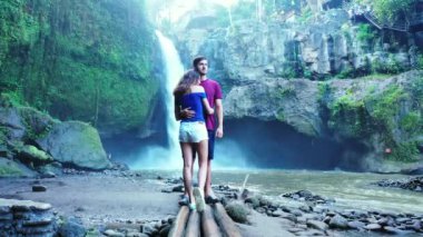 Romantik turistlerin, şelalenin yanında yan yana durdukları bir video.  