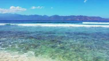 Dağların arkasında köpüklü dalgalar. Bali 'nin yaz deniz manzarası.