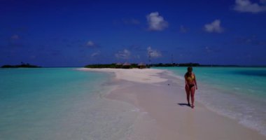 Bikini giyen, deniz tırpanı üzerinde yürüyen, bir şey düşünen bronz tenli kızın videosu. 