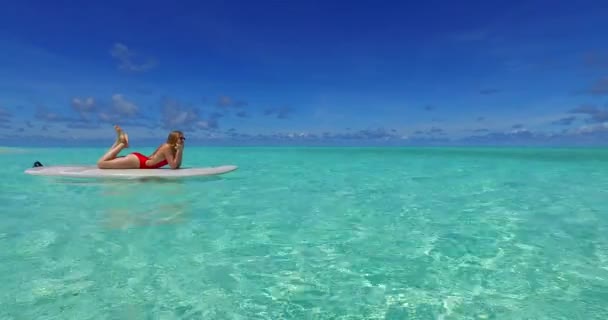 多明尼加共和国碧绿的海洋中 一对年轻夫妇在冲浪板上一起冲浪 — 图库视频影像