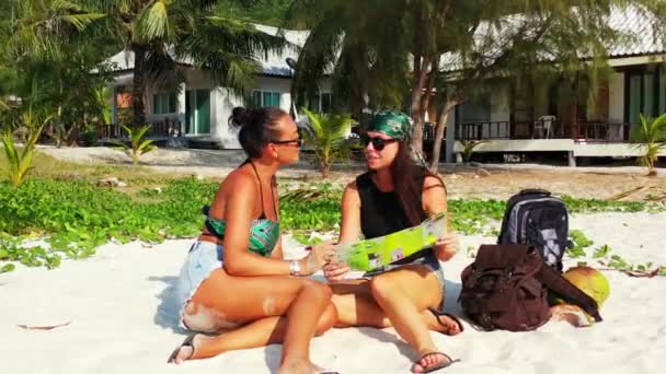 Twee Jonge Vriendinnen Die Aan Zandige Zeekust Zitten Met Bagage — Stockvideo