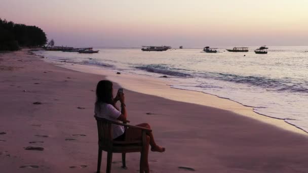 Dziewczyna Siedzi Krześle Piaszczystej Plaży Zachód Słońca — Wideo stockowe