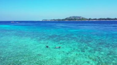Turistler, arka planda dağlar olan sıcak turuaz suyunun tadını çıkarıyorlar. Endonezya, Bali 'ye tropikal yolculuk.