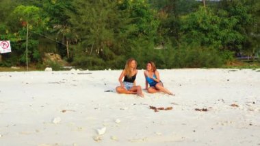 Tropik adanın kumlu sahillerinde dinlenen kızlar, yaz tatili konsept görüntüleri 