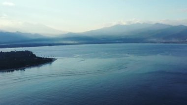 Bulanık dağları olan gün batımı deniz manzarası. Gili Trawangan, Endonezya 'nın doğal manzarası.