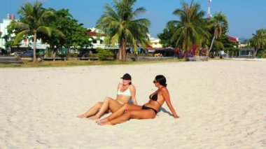 Güzel bayan arkadaşlar kumsalda güneşleniyor. 