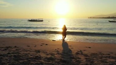 Kumsalda yürüyen bir kadın