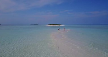 Genç bir adam ve kadın deniz suyunda yürüyorlar. Tropik bir tatil köyünde dinlenen güzel bir çift.    
