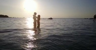 Dominik Cumhuriyeti 'nde gün batımında plajda dinlenen tatlı bir çift..