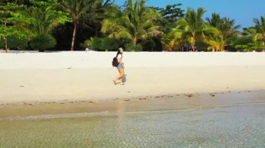 Sırt çantalı kadın turist tropik ada sahillerinde yürüyor, yaz tatili konsepti  