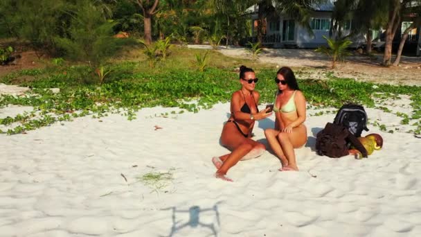 Dos Amigas Jóvenes Bikini Yacían Costa Arenosa Del Mar Haciendo — Vídeo de stock