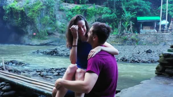 滝や川の近くに屋外で一緒に立って観光客のロマンチックなカップル — ストック動画