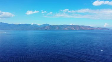 Arka planda dev dağlar olan mavi deniz manzarası. Bali 'nin yaz manzarası. 