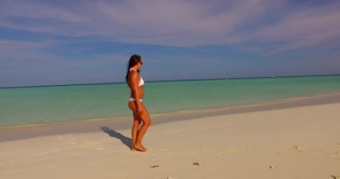 Kumsalda beyaz bikinili mutlu bir kadın. Tatil, güzel deniz ve doğal yaşam..