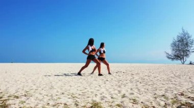 Sahilde egzersiz yapan çekici atletik kadınlar. 