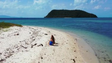 İki kızın kumsalda oturup birbirleriyle konuşarak güzel vakit geçirmesini izlemek.