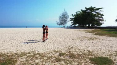 Sahilde egzersiz yapan çekici atletik kadınlar. 