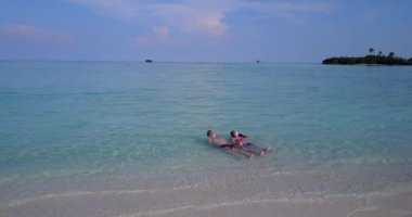 Çekici kız arkadaşıyla tropik okyanusta dinlenen bir adam. Yaz yolculuğu konsepti videosu