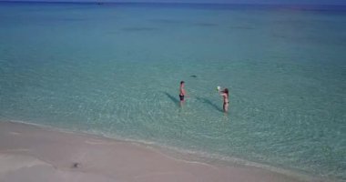 Genç adam ve kadın deniz suyunda valeybol oynuyorlar. Tropik bir tatil köyünde dinlenen güzel bir çift.    