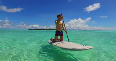 Yakışıklı adam raket üzerinde dinleniyor.  