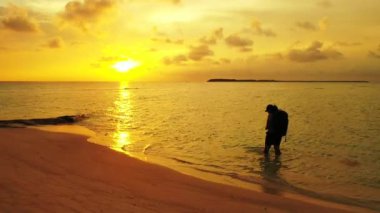 Gün batımında sahilde bir kadın silueti
