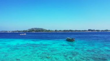 Parlak turkuaz deniz kıyısında uçan insansız hava aracı. Bora Bora 'daki tropik cennet, Fransız Polinezyası.