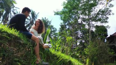 Erkek arkadaşıyla çimenlerde oturan çekici genç bir kadın, seyahat konsepti görüntüleri. 