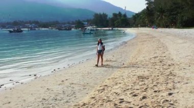 Sırt çantalı kadın turist tropik ada sahillerinde yürüyor, yaz tatili konsepti  