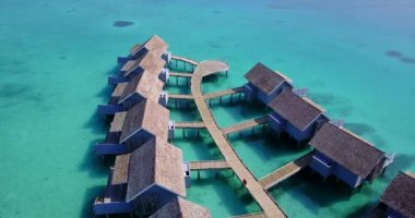 İskeleli ve turkuaz deniz arka planlı rahat bungalovlar. Bali Doğal Sahnesi.