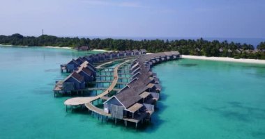 Beyaz kumlu plajlı sahil adalarının havadan görüntüsü, evlerin çatıları, ahşap iskele.