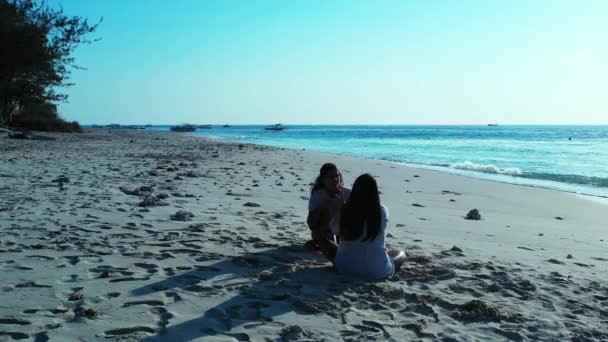 女孩们白天坐在沙滩上 — 图库视频影像