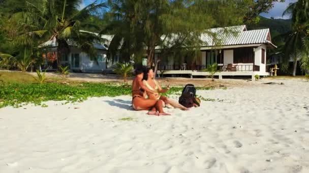 Twee Jonge Vriendinnen Bikini Lagen Aan Zandige Zeekust Een Meisje — Stockvideo