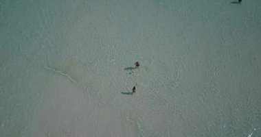 Genç adam ve kadın deniz suyunda valeybol oynuyorlar. Tropik bir tatil köyünde dinlenen güzel bir çift.    