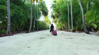 Tropikal yaz tatilinde bavuluyla gezen kadın turist seyahat tatillerinde dinleniyor..