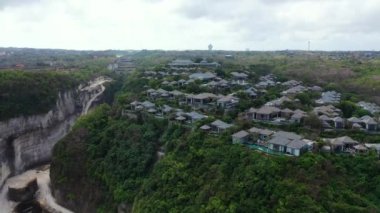 Yeşil kayalık kanyondaki binaların havadan görünüşü. Bora Bora 'ya seyahat, Fransız Polinezyası.