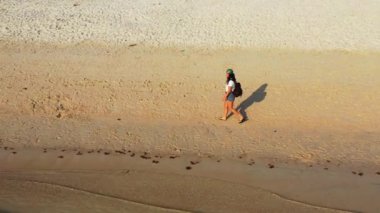 Sırt çantalı kadın turist tropik ada sahillerinde yürüyor, yaz tatili konsepti  