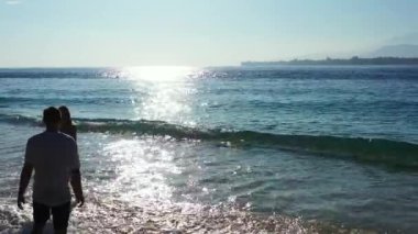 Güzel genç çift tatilin tadını çıkarıyor ve okyanusun yakınındaki güzel tropikal sahilde dinleniyor. 