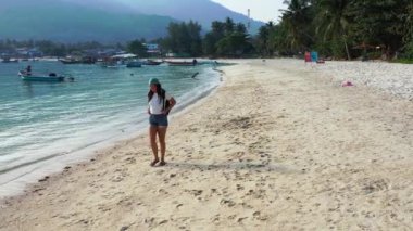 Sırt çantalı kadın turist tropik ada sahillerinde yürüyor, yaz tatili konsepti  