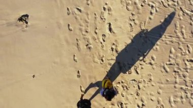 Kumsalda yürüyen sırt çantalı iki kadının hava görüntüleri.