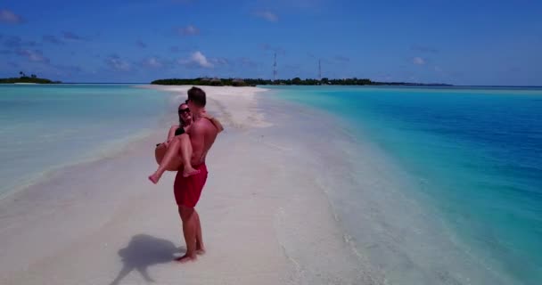 马尔代夫一位英俊的白人男子和一位美丽的女子在沙滩上玩乐 — 图库视频影像