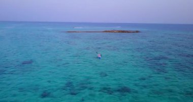 İnsanlar denizde küçük bir teknede kürek çekiyorlar. Endonezya, Bali 'ye tropikal yolculuk.