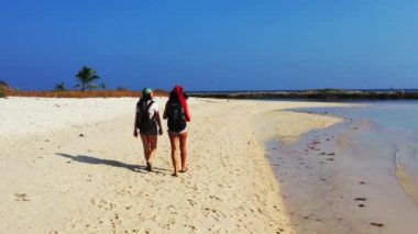 Sahilde yürüyen kadınların yüksek açılı görüntüleri. 
