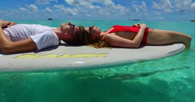Çekici kız arkadaşıyla tropik okyanusta dinlenen bir adam. Yaz yolculuğu konsepti videosu