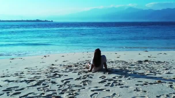 女孩坐在沙滩上放松 — 图库视频影像