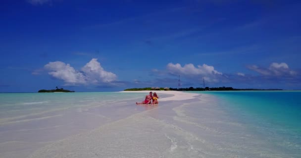 若い素敵なカップルは モルディブの熱帯島の海の近くのビーチで休息して休暇を楽しんでいます — ストック動画