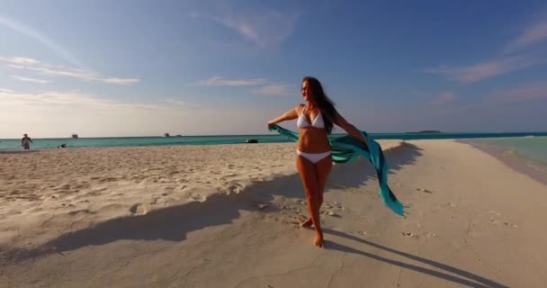 身穿白色比基尼的年轻貌美的女子走在美丽的热带海滩上 碧绿的海水和洁白的沙滩上 — 图库视频影像
